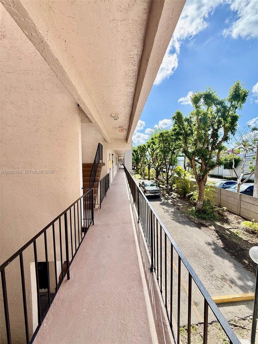 1950 West 54th Street, Unit 115 Hialeah, FL 33012 - Photo 23 of 28 a view of a house with balcony and wooden stairs