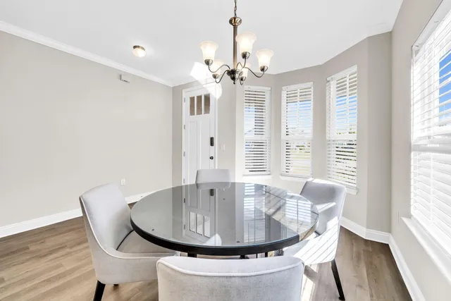 a dining room with furniture a chandelier and wooden floor