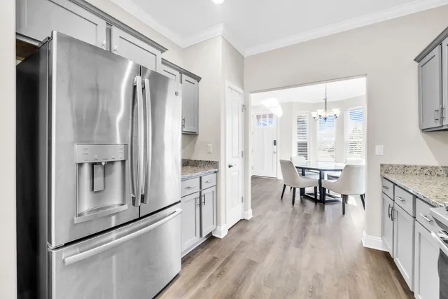 a kitchen with stainless steel appliances granite countertop a refrigerator and a stove top oven