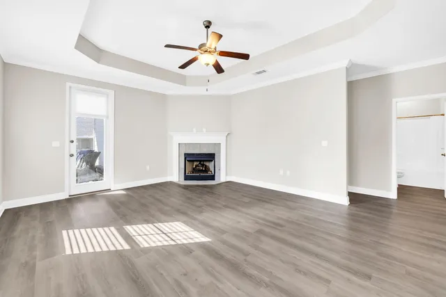 a view of empty room with wooden floor and fireplace