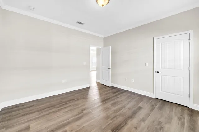 a view of an empty room with wooden floor