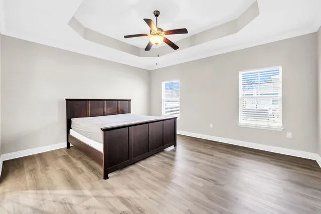 a living room with a bed furniture chandelier and a window