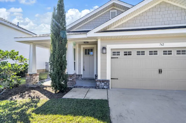 a view of a house with backyard and trees
