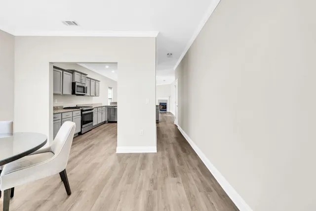 a view of a hallway with wooden floor and furniture
