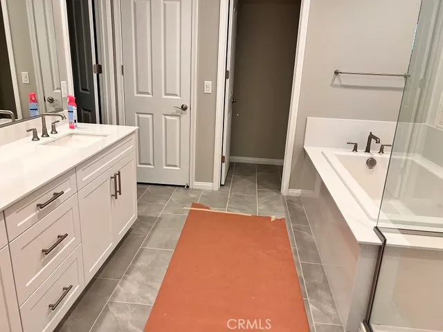 a bathroom with a double vanity sink a mirror and a bathtub