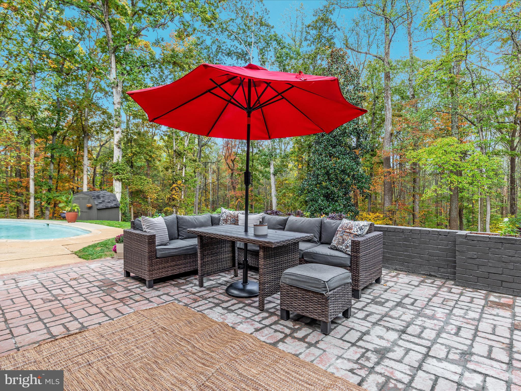 7261 Baldwin Ridge Road Warrenton, VA 20187 - Photo 12 of 76 a view of a patio with couches and table under an umbrella