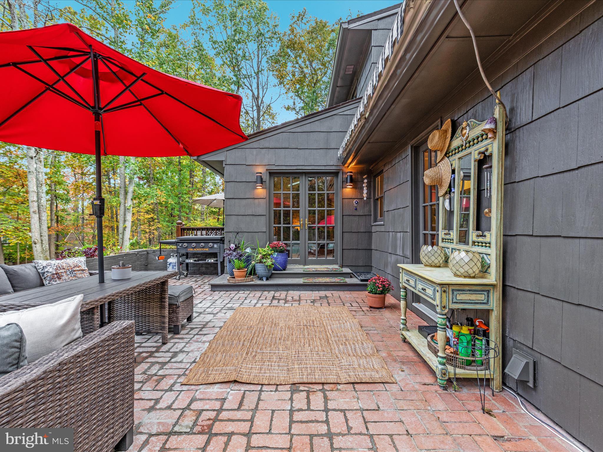 7261 Baldwin Ridge Road Warrenton, VA 20187 - Photo 13 of 76 a patio with tables and chairs under an umbrella