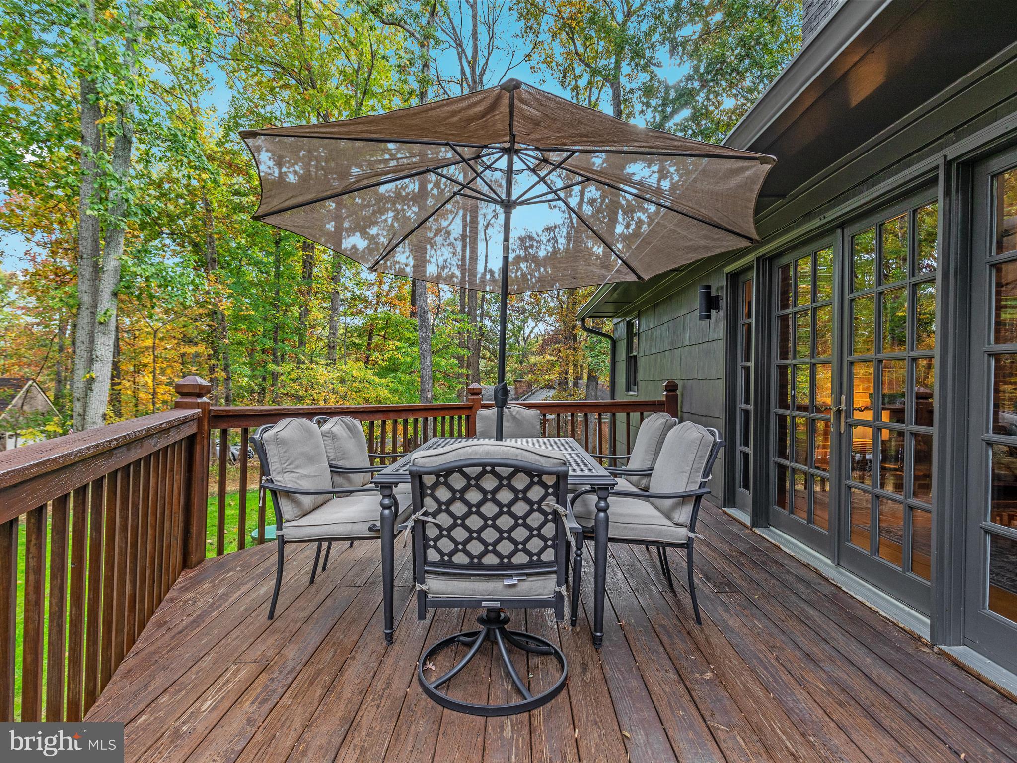 7261 Baldwin Ridge Road Warrenton, VA 20187 - Photo 21 of 76 a view of a deck with table and chairs under an umbrella with wooden floor