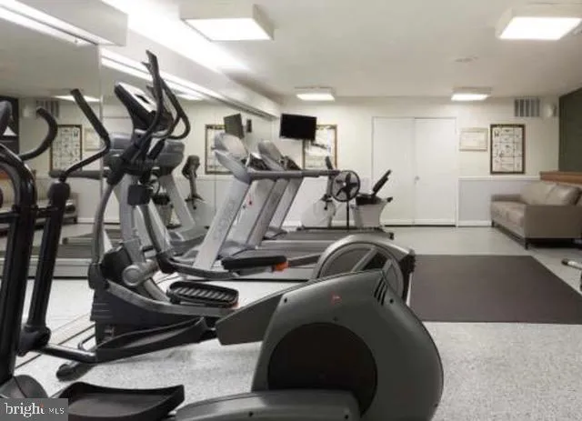 a room with gym equipment and a view of living room