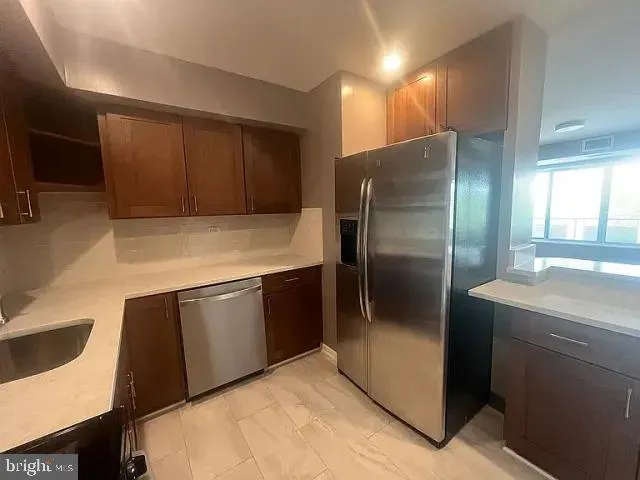 a kitchen with stainless steel appliances granite countertop a refrigerator a sink a stove and island