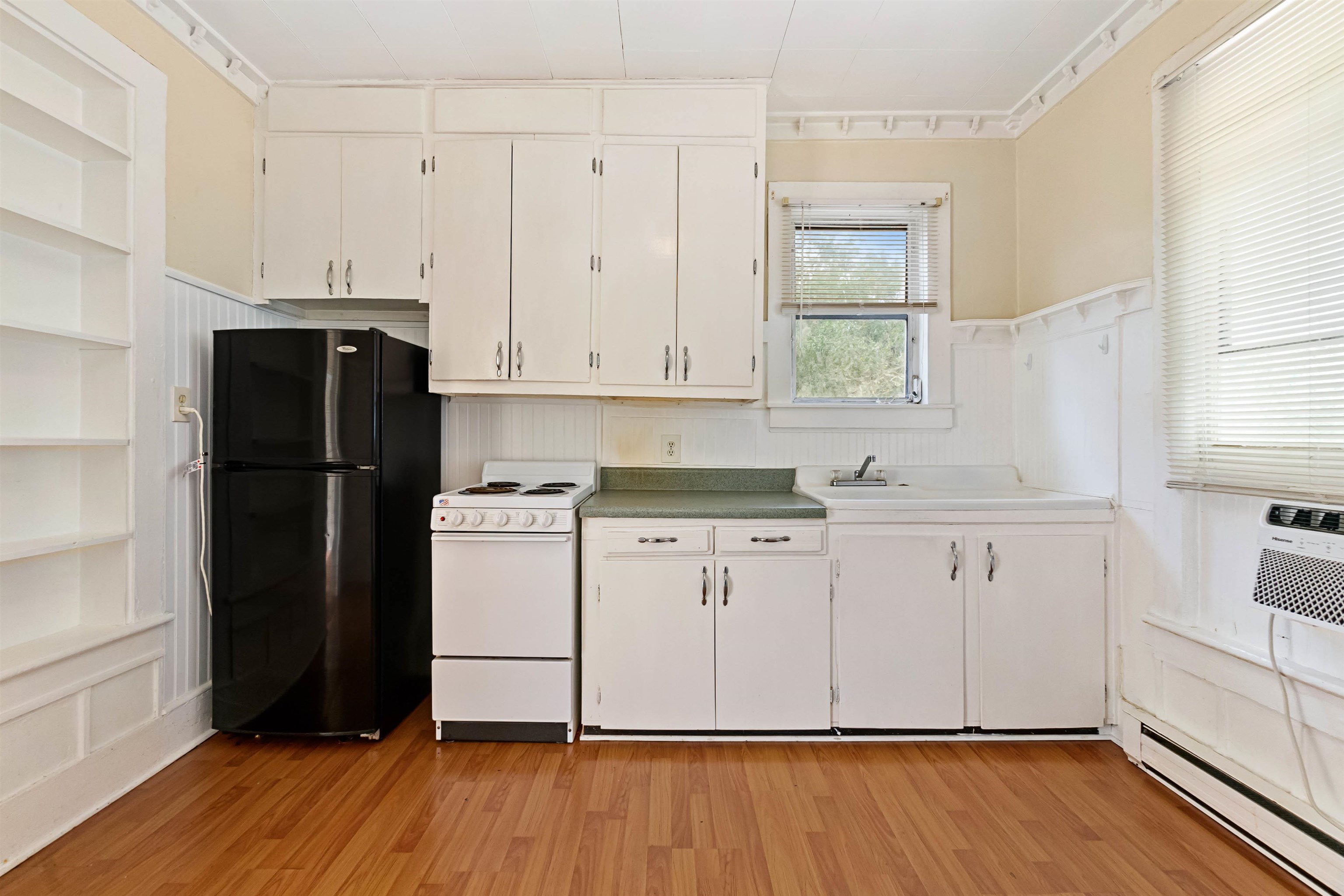 18 Arenta Street St. Augustine, FL 32084 - Photo 24 of 44 Kitchen featuring a baseboard radiator, freestanding refrigerator, white electric range oven, a wainscoted wall, and white cabinets