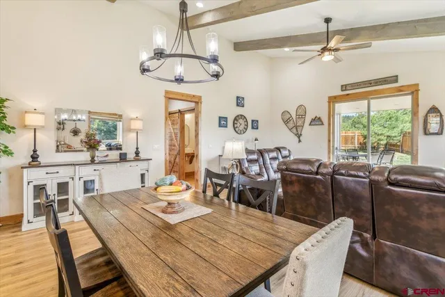 a dining room with wooden floor a chandelier a wooden table and chairs