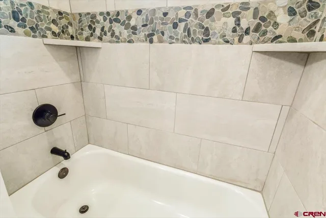 a bathroom with a granite countertop shower a mirror and a sink