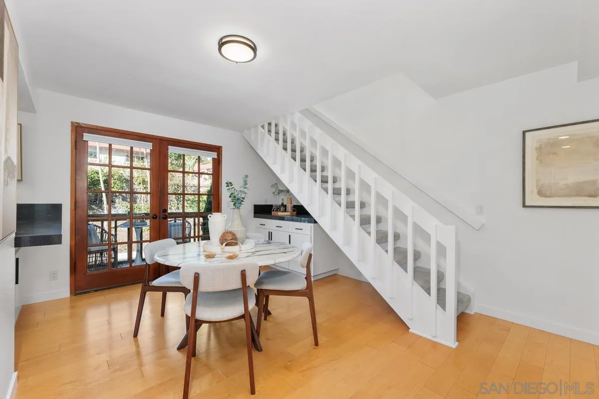 2364 Altisma Way, Unit B Carlsbad, CA 92009 - Photo 13 of 26 a dining room with furniture a chandelier and wooden floor