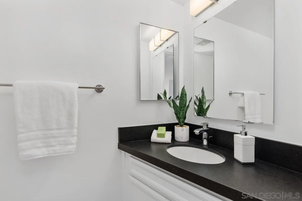 2364 Altisma Way, Unit B Carlsbad, CA 92009 - Photo 17 of 26 a bathroom with a granite countertop sink and a mirror