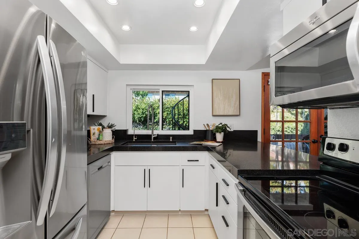 2364 Altisma Way, Unit B Carlsbad, CA 92009 - Photo 3 of 26 a kitchen with granite countertop a sink stainless steel appliances and window