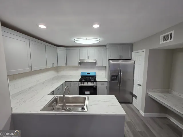 a kitchen with a sink a refrigerator and cabinets