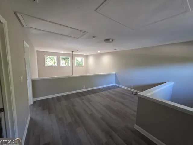 a view of a room with wooden floor