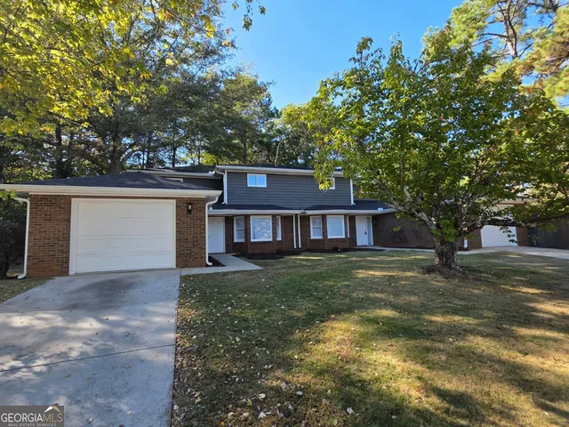 a view of a yard in front of a house with large tree
