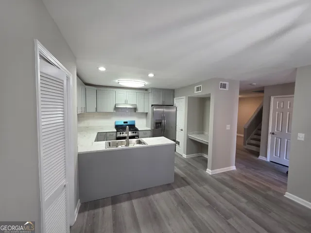 a kitchen with stainless steel appliances a refrigerator sink and cabinets