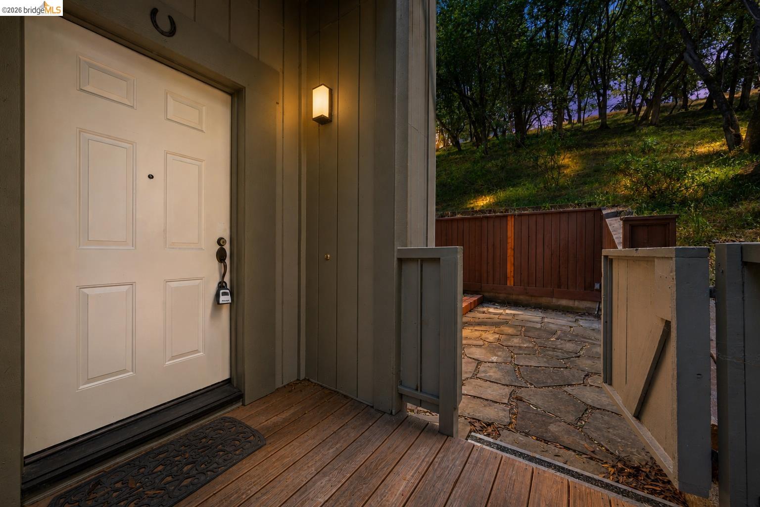 261 Redhawk Road Novato, CA 94949 - Photo 9 of 44 Front entry featuring a solid paneled door, wood-finish decking, and a wall-mounted exterior light fixture