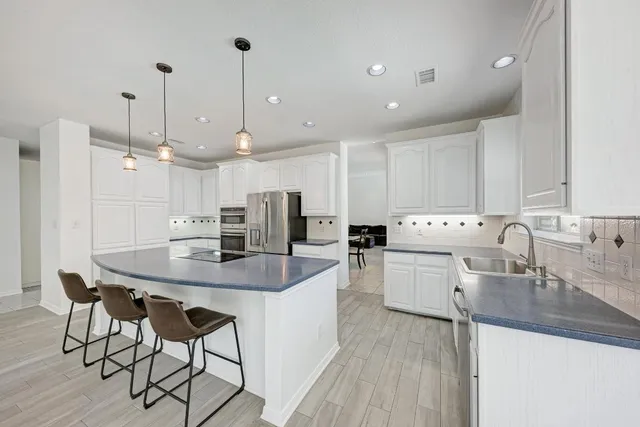 a kitchen with a sink a counter space appliances and cabinets