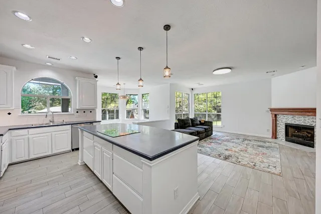a kitchen with granite countertop a stove a sink and a refrigerator
