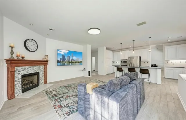 a living room with furniture a fireplace and kitchen view