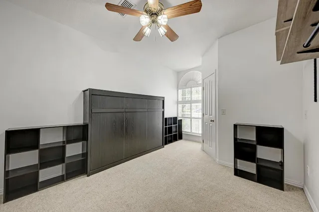 a view of empty room with cabinet and ceiling fan