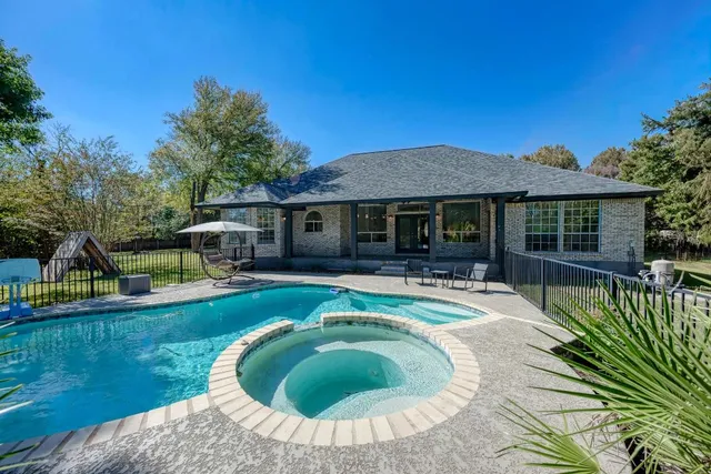 a view of a house with swimming pool and sitting area