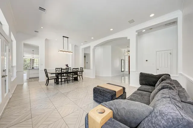 a living room with furniture and a dining table with kitchen view