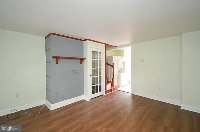 an empty room with wooden floor and closet