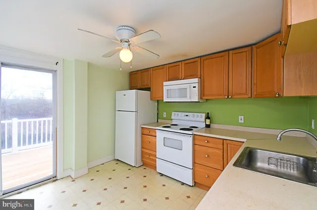 a kitchen with a sink a refrigerator and cabinets