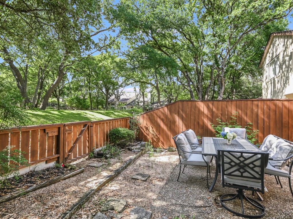 8314 Bent Tree Road Austin, TX 78759 - Photo 14 of 15 a view of backyard with table and chairs and wooden fence