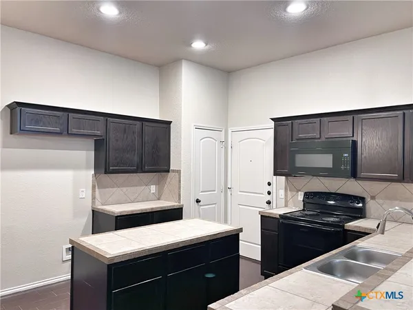 a kitchen with a sink and a stove top oven