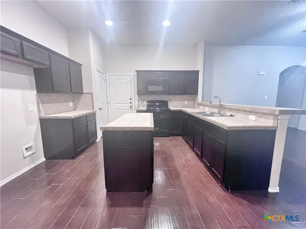 a kitchen with a sink a stove a refrigerator and a oven