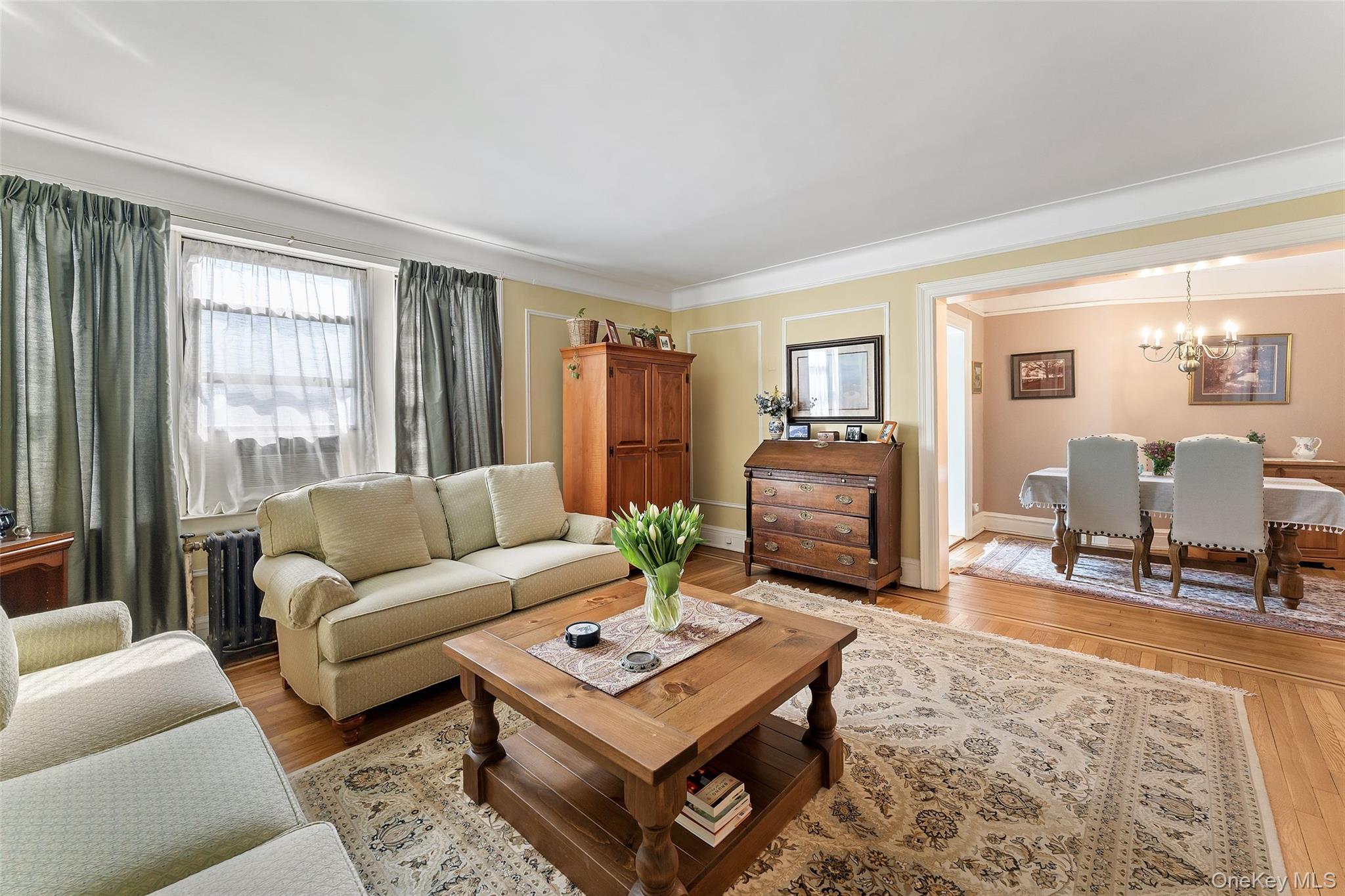 42 Pondfield Road West, Unit 6D Bronxville, NY 10708 - Photo 4 of 15 a living room with furniture a table and a large window