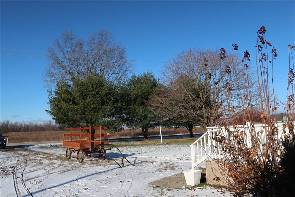 664 Airport Road Mercer, PA 16137 - Photo 19 of 20 a backyard of a house with table and chairs under an umbrella