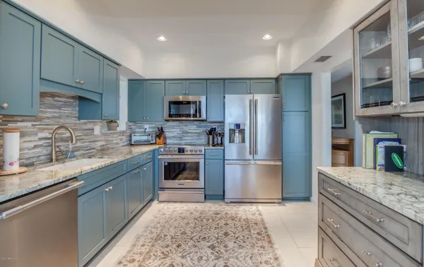 a kitchen with granite countertop a refrigerator and a sink
