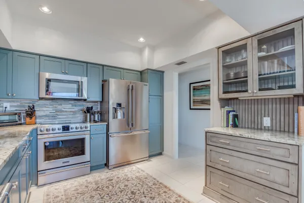 a kitchen with stainless steel appliances granite countertop a refrigerator and a stove top oven