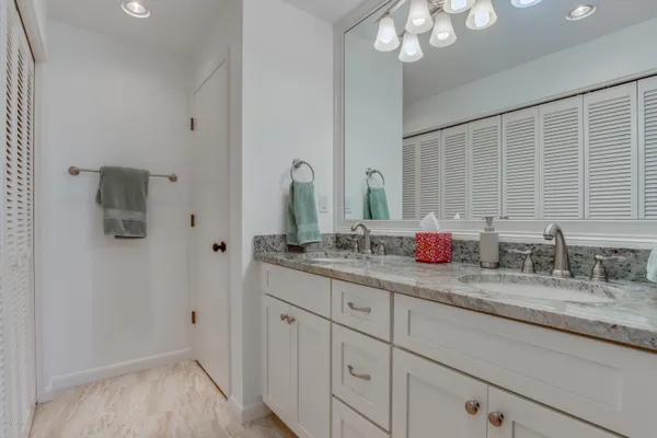 a bathroom with a granite countertop sink a mirror and a shower