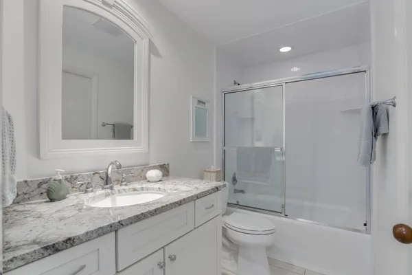 a bathroom with a granite countertop sink toilet and shower