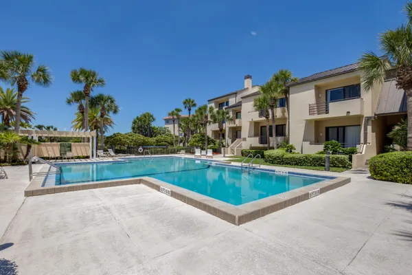a view of swimming pool with outdoor seating and house in the background