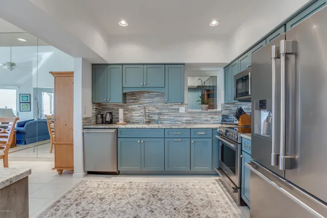 a kitchen with stainless steel appliances granite countertop a refrigerator sink and stove