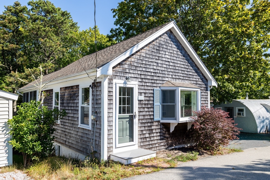 a front view of house with yard and trees in the background