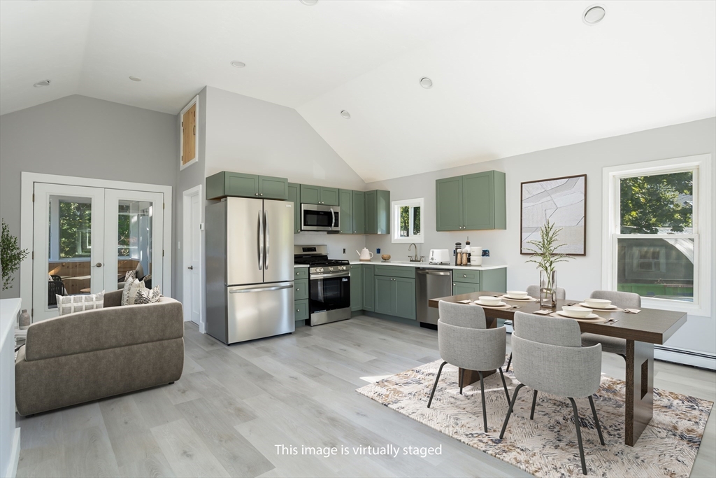3 A Thompson Road, Unit A Bourne, MA 02532 - Photo 11 of 42 a kitchen with a refrigerator a stove a dining table and chairs