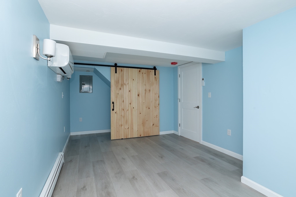3 A Thompson Road, Unit A Bourne, MA 02532 - Photo 37 of 42 an empty room with wooden floor and cabinet