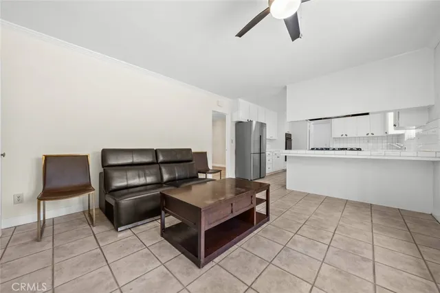 a living room with stainless steel appliances kitchen island granite countertop a refrigerator and a stove