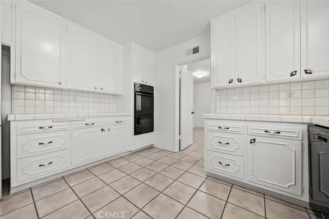 a kitchen with white cabinets and white appliances