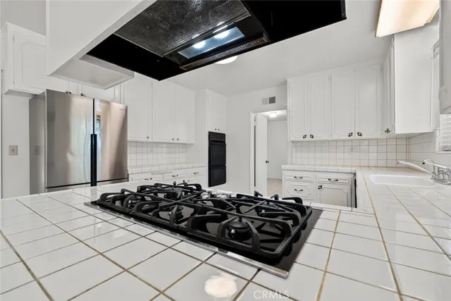 a kitchen with stainless steel appliances a stove a sink and a refrigerator